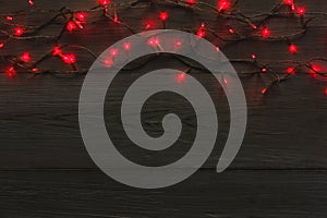 Christmas red lights border on grey wooden background