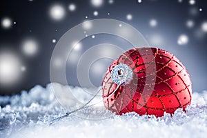 Christmas red Luxury ball in snow and abstract snowy atmosphere