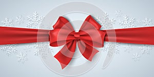 Christmas red ribbon with bowknot on the background of paper snowflakes. Luxury, silk tape. Happy new year concept. Graphic for