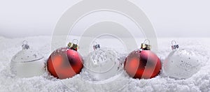 Christmas red and white baubles in snow