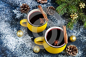 Christmas red wine mulled wine with spices and in large, yellow mugs.