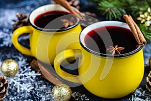 Christmas red wine mulled wine with spices and in large, yellow mugs.