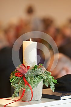 Christmas, religion and candle with mistletoe in church, bible and holy book or gospel on table for worship to God