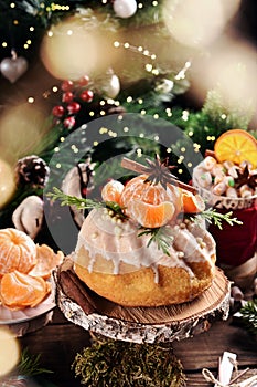 Christmas ring cake with fresh mandarin decoration on festive table in rustic style