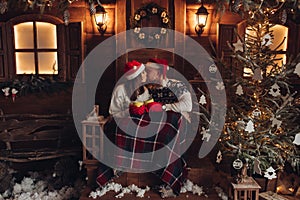 Christmas romance in Santa Claus hats beautiful house New Year`s atmosphere