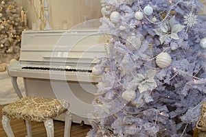 White Christmas tree decorated with silver and pink ornaments at the piano background.Winter scene. New Year decoration.Xmas