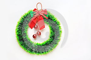 Christmas round wreath with ribbon and red ball hanging on white background