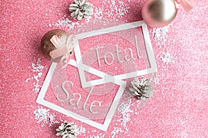 Christmas sale with baubles on pink glitter background.