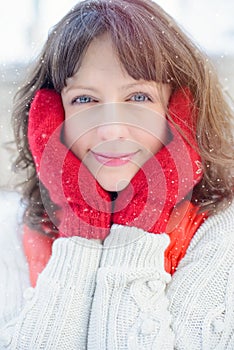 Christmas sale. Beautiful surprised woman in red mitts and white sweater winter background with snow, emotions. Funny laughter wom