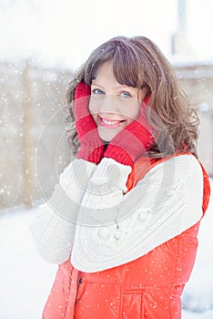 Christmas sale. Beautiful surprised woman in red mitts and white sweater winter background with snow, emotions. Funny laughter wom