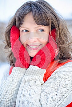 Christmas sale. Beautiful surprised woman in red mitts and white sweater winter background with snow, emotions. Funny laughter wom