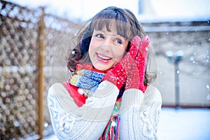 Christmas sale. Beautiful surprised woman in red mitts and white sweater winter background with snow, emotions. Funny laughter wom