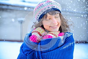 Christmas sale. Beautiful surprised woman in red mitts and white sweater winter background with snow, emotions. Funny laughter wom