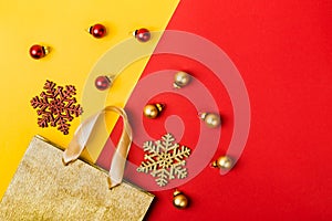 Christmas sale concept. Golden Paper shopping bag, snowflakes and balls on geometric yellow red background
