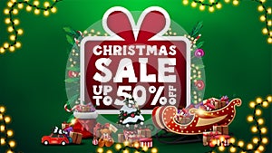 Christmas sale, up to 50% off, green discount banner with large cartoon present with large offer decorated with Christmas tree