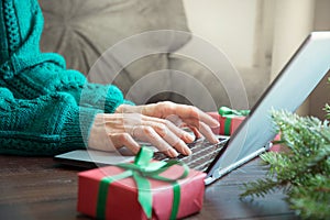 Christmas sales. Woman typing on laptop in home interior. Xmas concept. Planing holidays