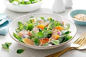 Christmas salmon orange salad with pine nuts, red onion and corn salad lettuce