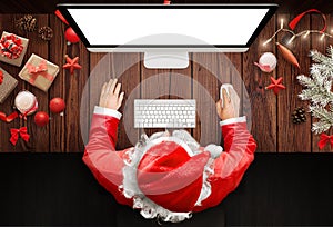 Christmas in Santa Claus home. Santa Claus use a computer to respond to letters