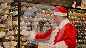 Christmas Santa Claus packing balls in box in his residence