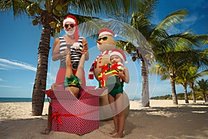 Christmas Santa Claus pulls out a child from a large gift box and a little girl is happy to receive many gifts.