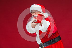 Christmas. Santa Claus with red bandages wound on his hands for boxing imitates kicks. Kickboxing, karate, boxing