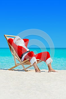 Christmas Santa Claus relax in deckchair at ocean sandy beach