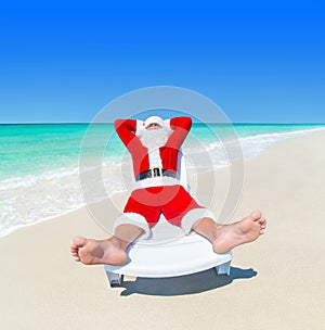 Christmas Santa Claus relax on sunlounger at ocean perfect beach