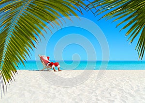 Christmas Santa Claus relaxing on sunlounger at ocean sandy tropical beach