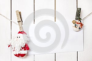 Christmas Santa Claus and snowman clothespin holding white paper