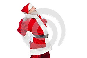 Christmas. Santa Claus is suffering from back pain and holds a red bag with gifts on his back. Isolated on white