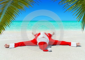 Christmas Santa Claus sunbathe at tropical ocean palm sandy beach