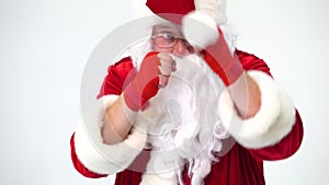 Christmas. Santa Claus on a white background in red bows for boxing and kickboxing fulfills blows. The image of a