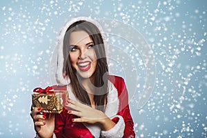 Christmas Santa hat woman portrait hold christmas gift boxs. Smiling happy girl on blue background. Portrait of beautiful girl