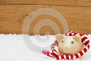 Christmas Savings, Piggy Bank with scarf on snow with copy-spac