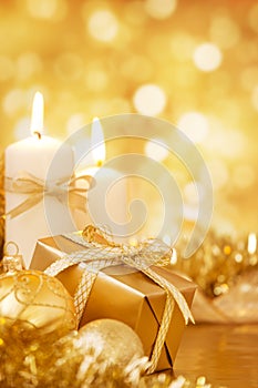 Christmas scene with gold baubles, gift and candles