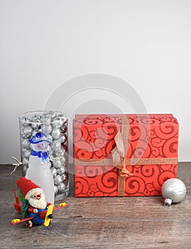 Christmas scene including wrapped present, snowman, and santa cl