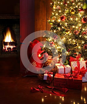 La scena del natale con albero, regali e fuoco sullo sfondo.