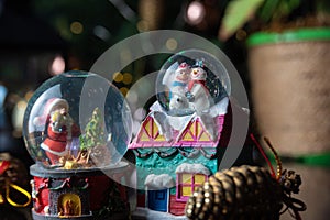 Christmas scene with tree, lights and snow globe. Selective focus on black background