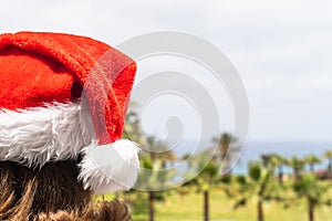 Christmas sea holiday. Woman in santa hat relaxing on paradise beach island with palm trees. New year.