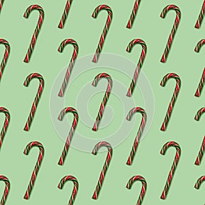 Christmas seamless pattern made with striped candy canes on green background