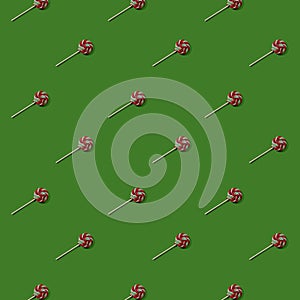 Christmas seamless pattern. Repeating lollipop on green background.