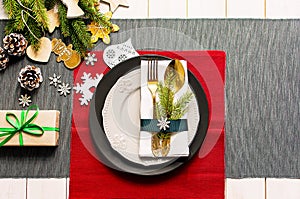 Christmas serving table. Traditional festive decoration background top view. Cutlery utensils beautiful plates decorative elements