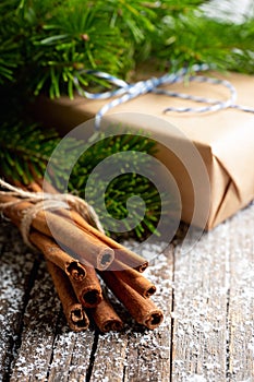 Christmas setting with bundle of cinnamon and pine branches on the rustic wooden background