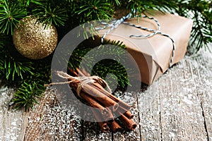 Christmas setting with bundle of cinnamon and pine branches on the rustic wooden background