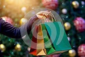 Christmas shopping bags in hand on christmas decoration h photo