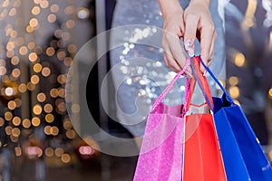 Christmas Shopping. Elegant woman in silver dress In Shopping Mall. Shopping Bags. Holidays and New Year Sales.Woman