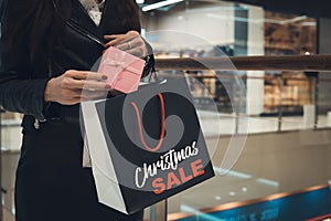 Christmas Shopping. Happy Woman with Shopping Bags in Shopping Mall.Sales. Christmas Gifts.Shopping Mall. woman`s hands put a