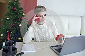 Christmas shopping on the Internet, boy rejoices at the received order in a gift box