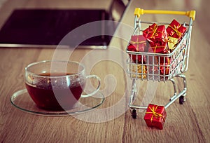 Christmas shopping online.  Thumbnail of a shopping trolley with laptop, bank card and glass of tea.  Concept.  Convenient shoppin