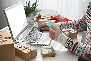 Christmas shopping online. Unrecognizable Man Hands holding Credit Card buying presents by using laptop.